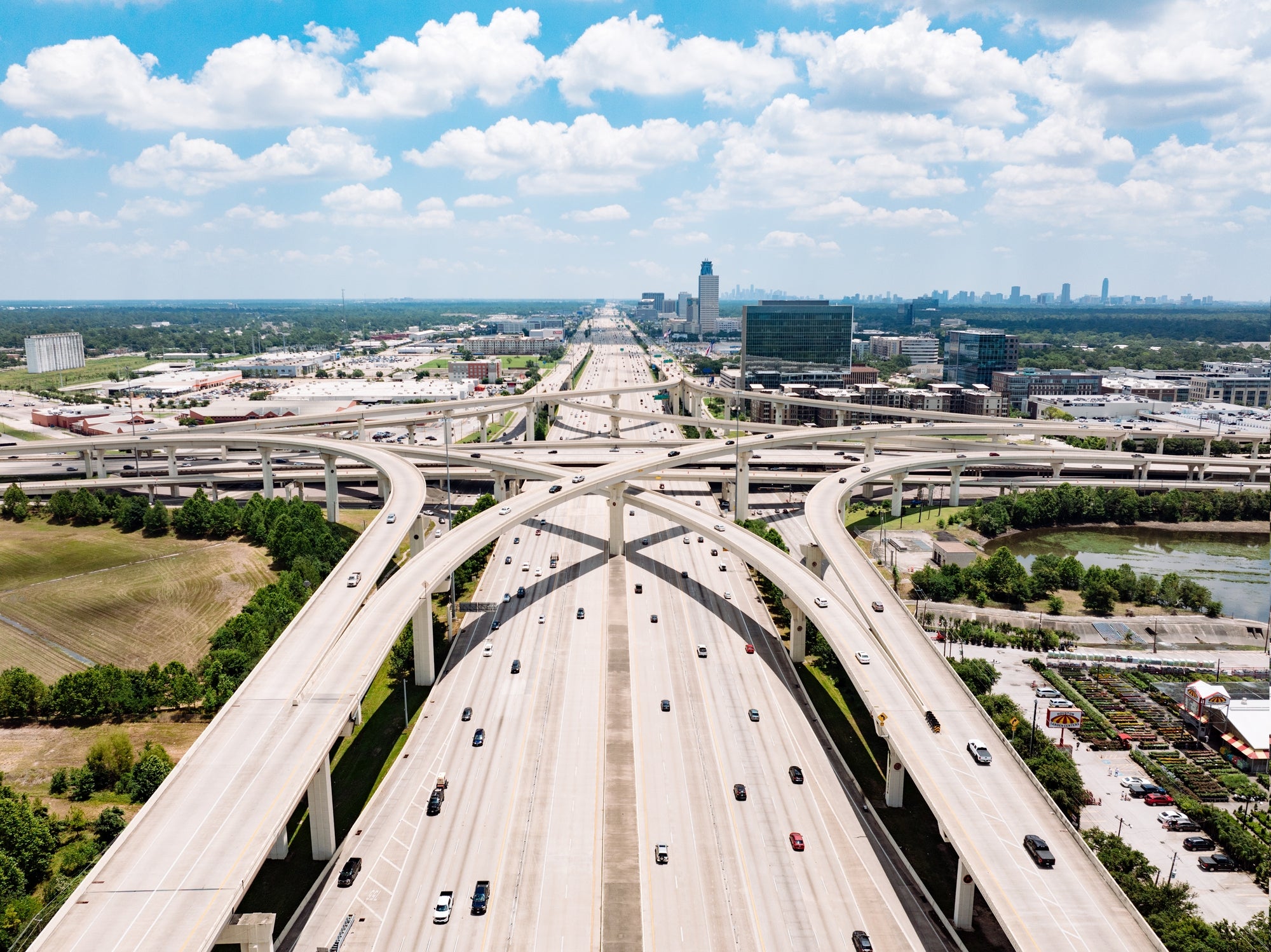 Aerial presumption    of a sprawling, multi-level road  interchange successful  a cityscape with disposable   cars driving on  the routes nether  a partially  cloudy sky