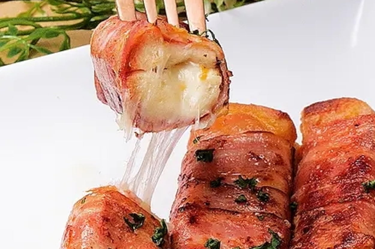 チーズが中に入ったフレンチトーストが皿に盛られ、フォークで持ち上げられています。