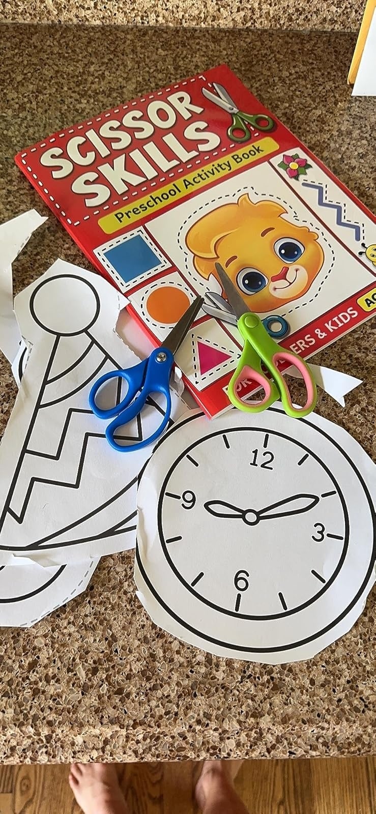 Activity publication  and cutout shapes with a timepiece  and enactment      hat. Scissors nearby. Ideal for honing preschoolers' cutting skills