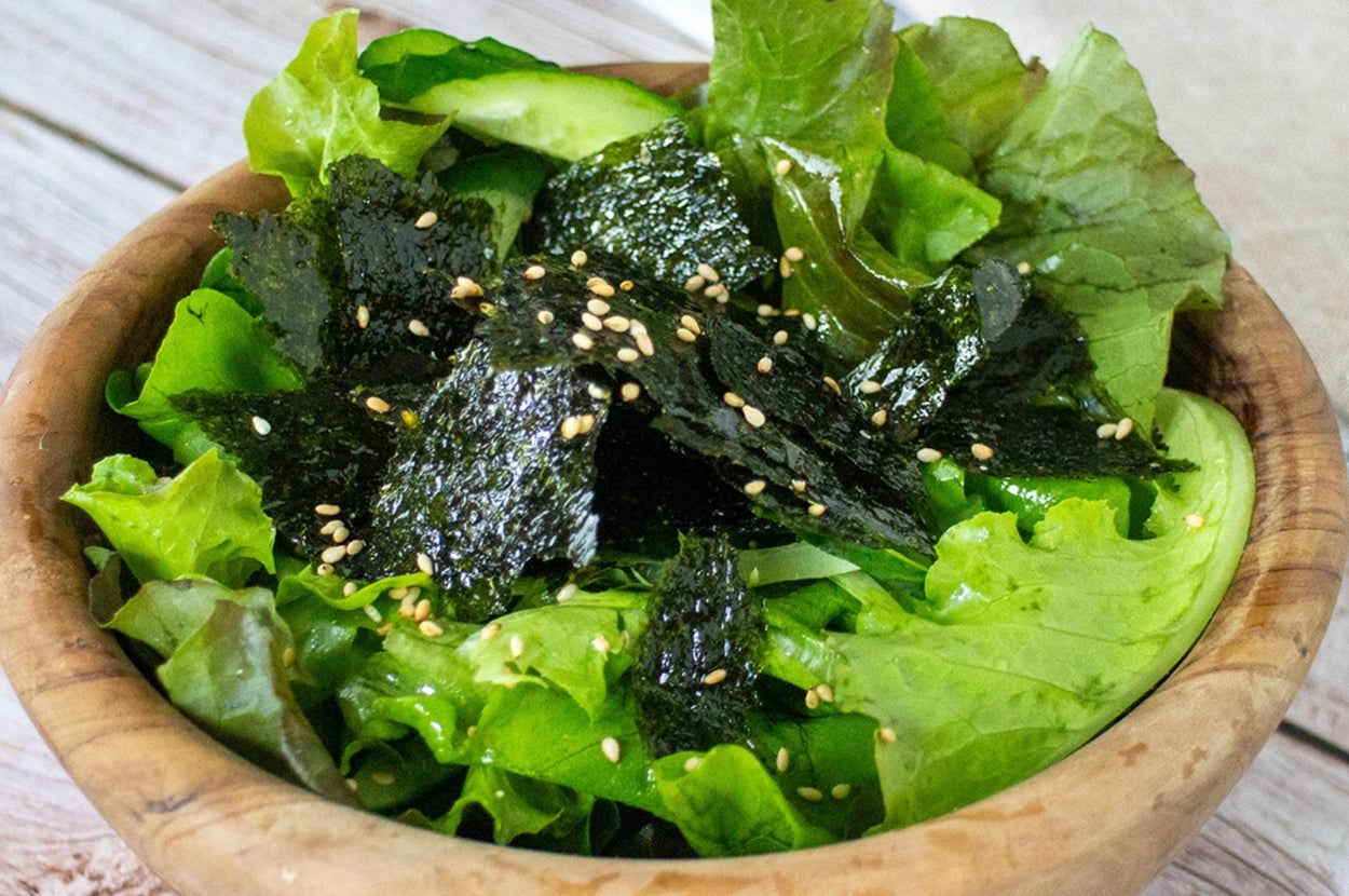 ボウルに入ったサラダ。レタス、海苔、ゴマがトッピングされている。