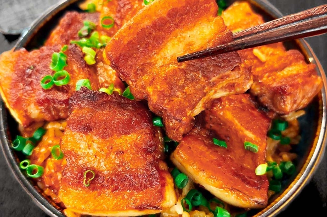 ラーメンの上に乗った厚切りチャーシューと刻みネギの美味しそうな器。