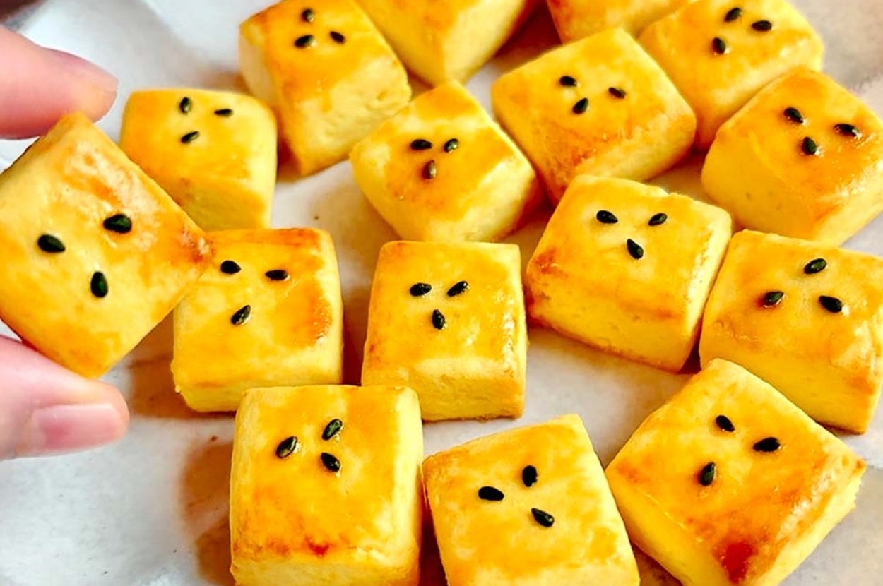 手作りのお菓子が皿に並べられている。手で一つつまんで見せている。