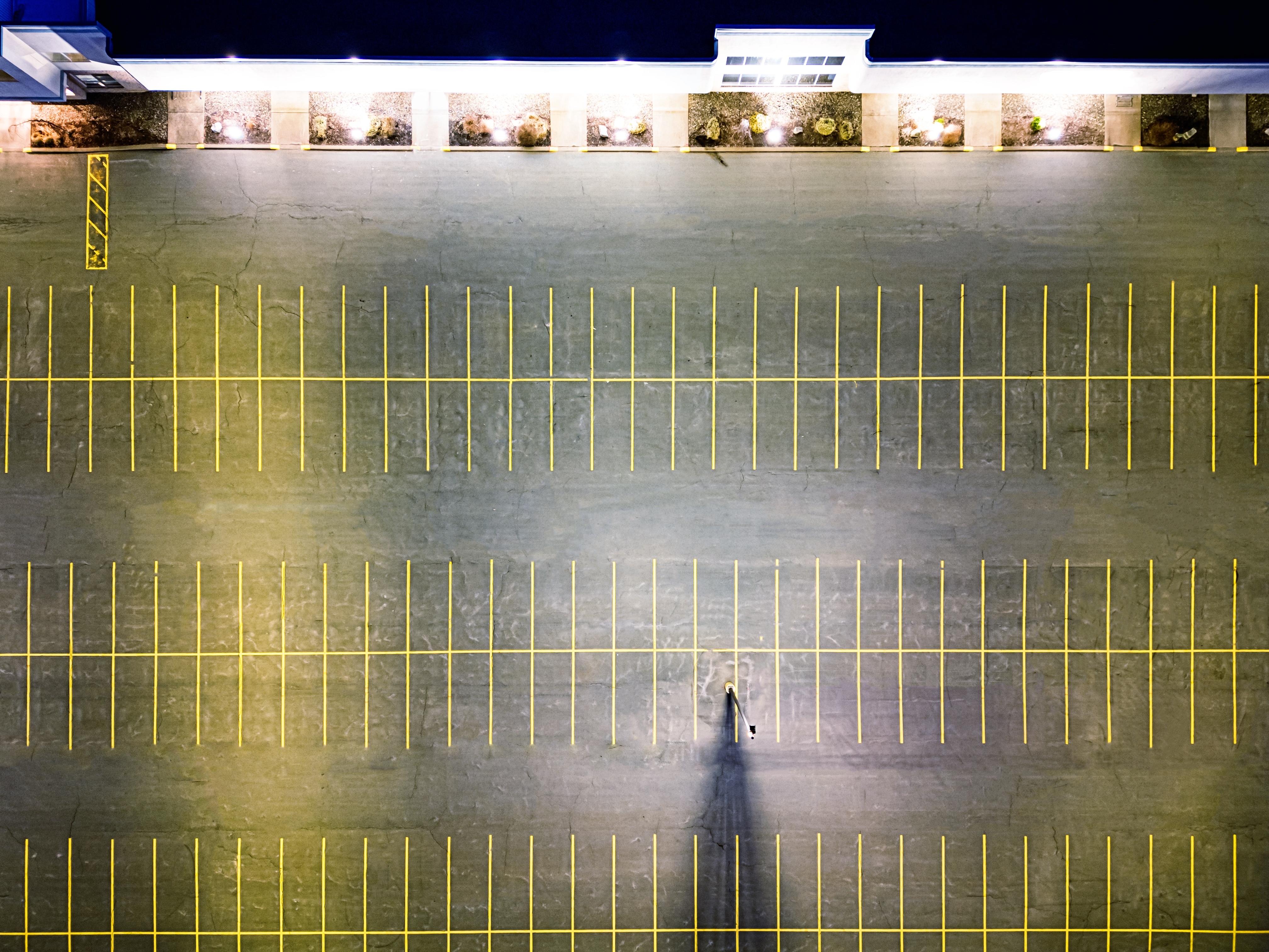 Aerial view of a large, empty parking lot at night.