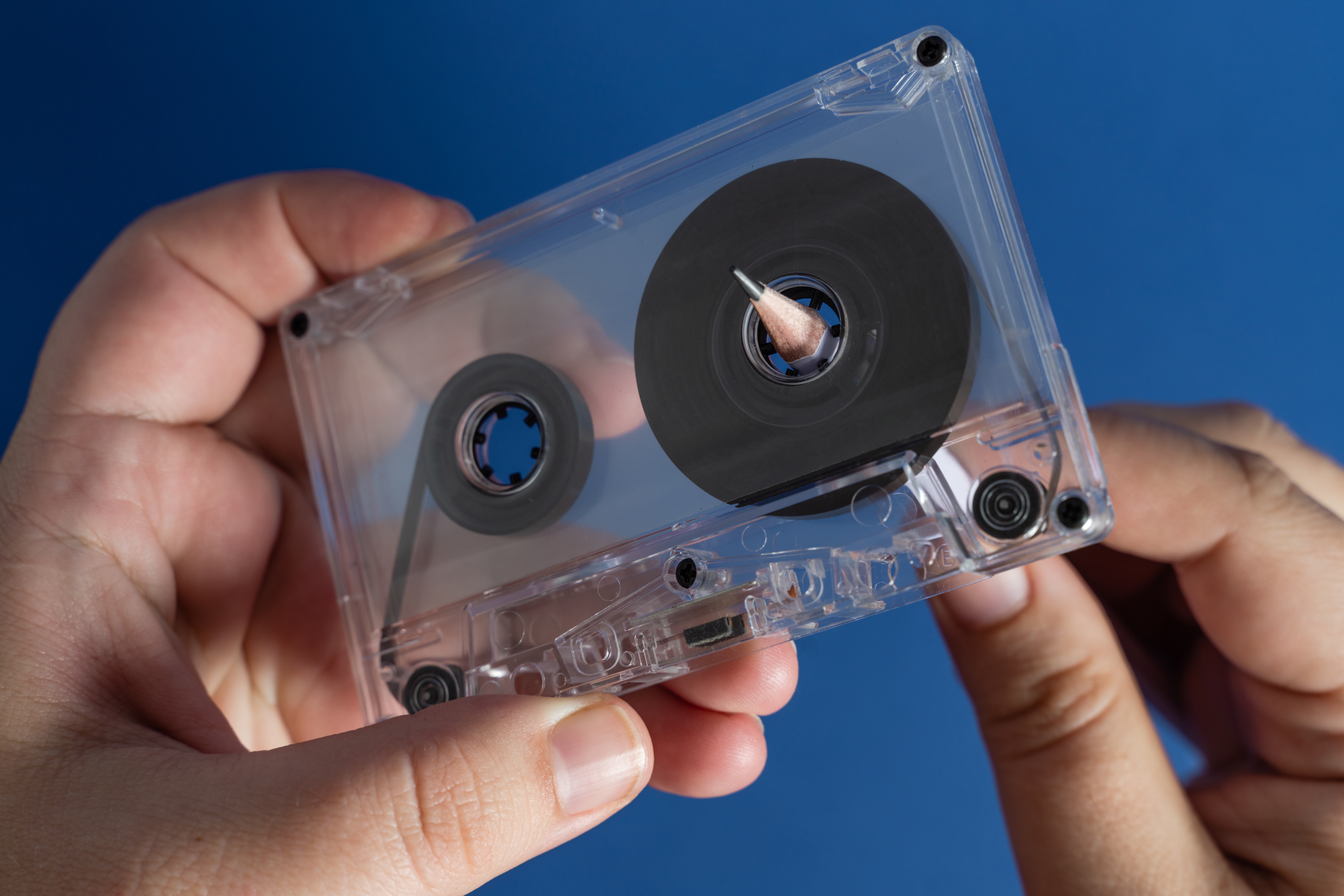 Hands holding a transparent cassette portion    with the portion    partially unwound