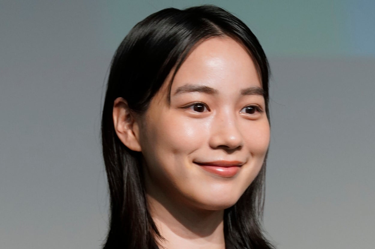 黒いジャケットを着た女性が微笑んでいる。