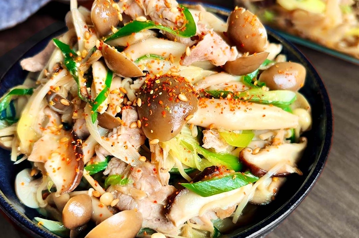 キノコと野菜がたっぷり入ったアジアンスタイルの一品料理がテーブルに盛り付けられています。