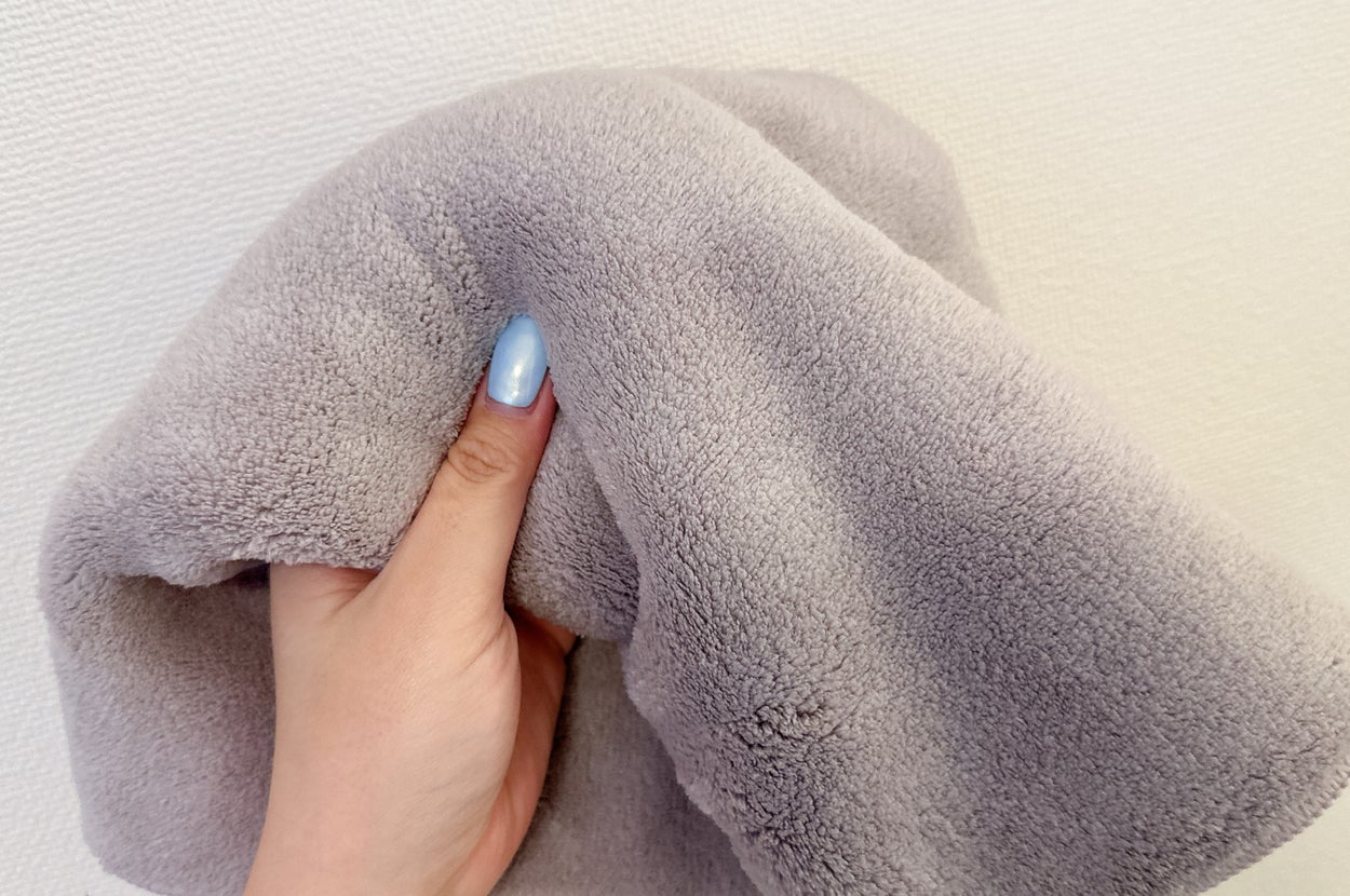 手が柔らかそうなタオルを持っているところ。タオルの手触りが伝わる様子。