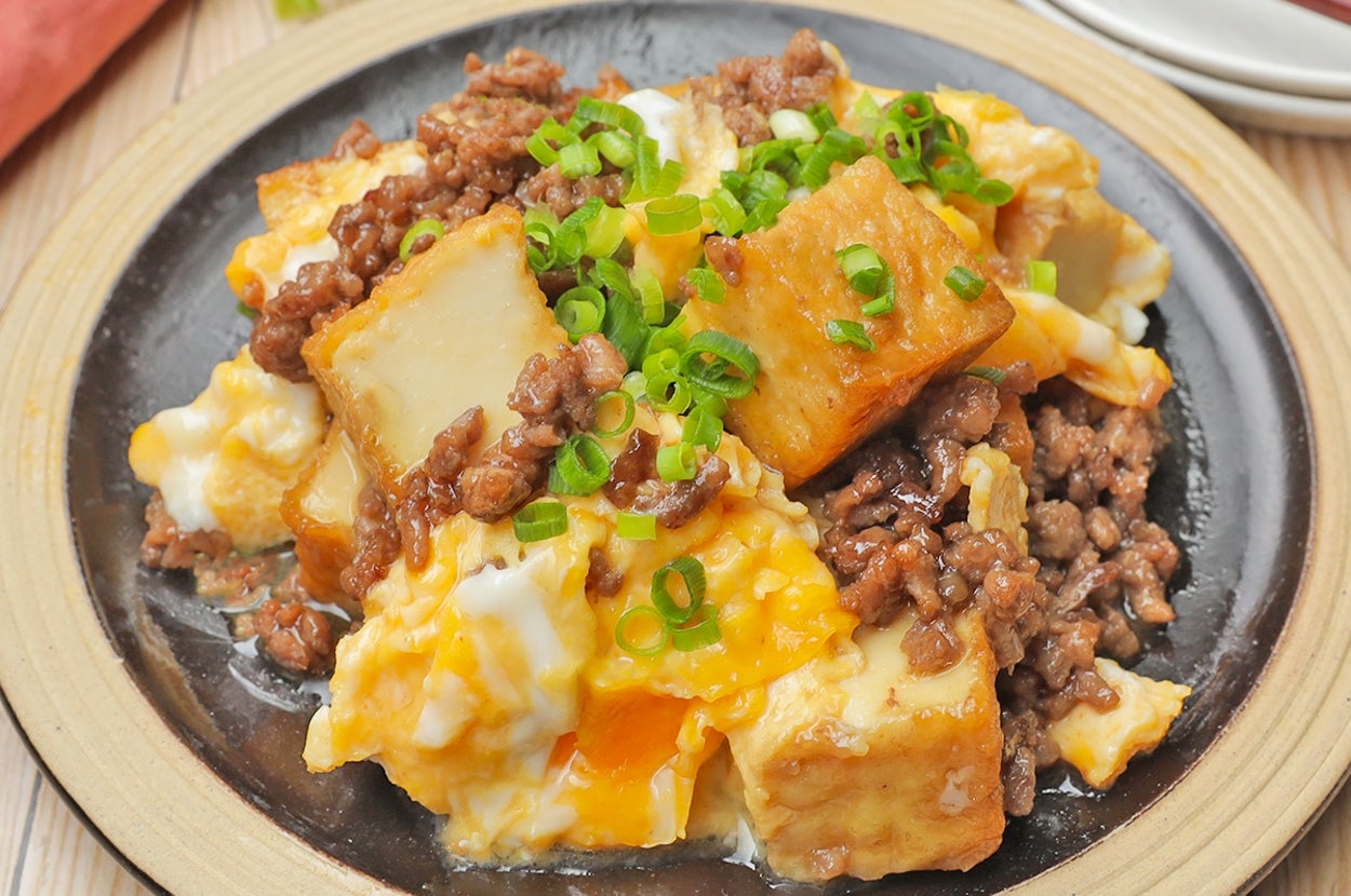 皿に盛り付けられた豆腐、ひき肉、卵の料理。上にネギがトッピングされ、美味しそうに仕上がっている。