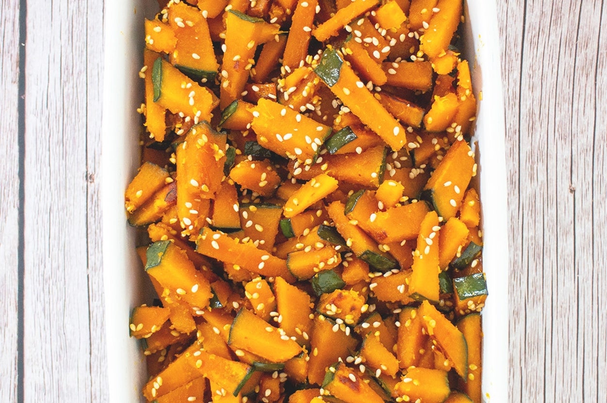 日本のかぼちゃ料理。切ったかぼちゃがゴマでトッピングされ、白い皿に盛り付けられている。