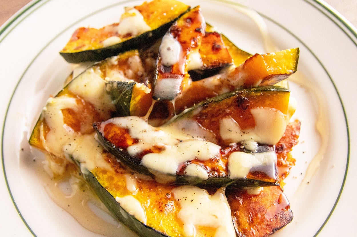 皿に盛られた焼きカボチャにチーズがかかった料理。