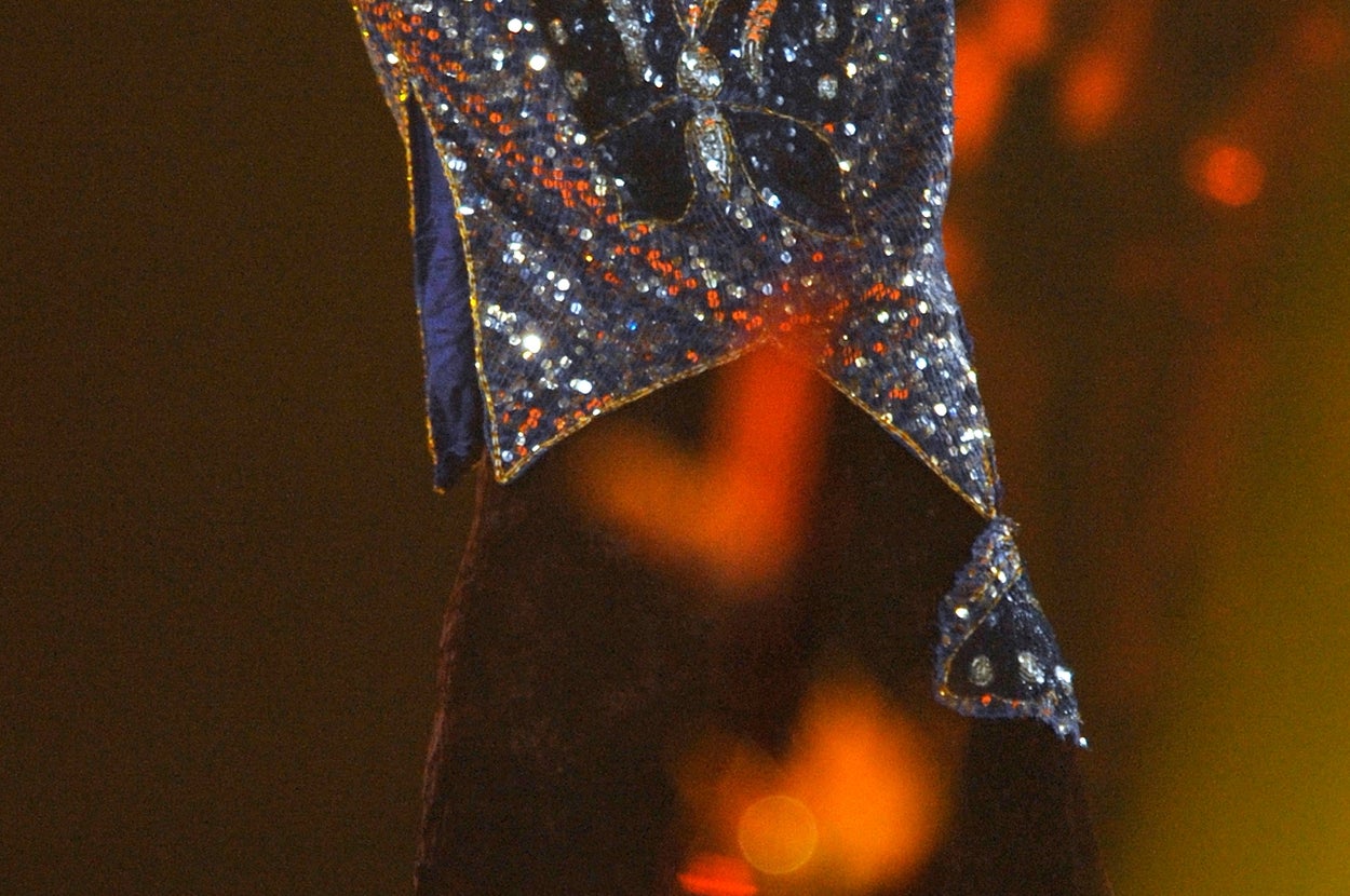 歌手がステージ上で両腕を広げて観客を盛り上げている。スパンコールのついた衣装を着用。