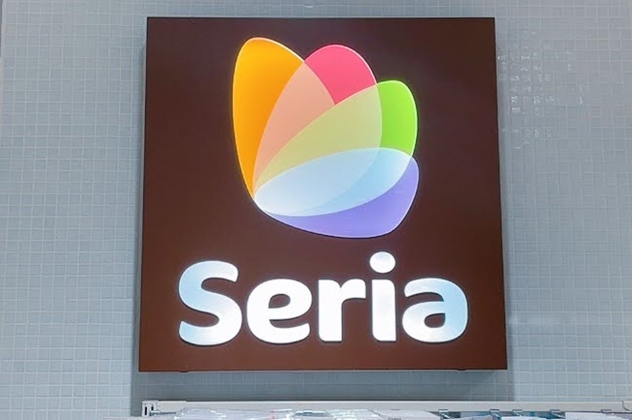 店内のSeria看板と商品の陳列棚。看板は白い壁に取り付けられ、店名が強調されている。