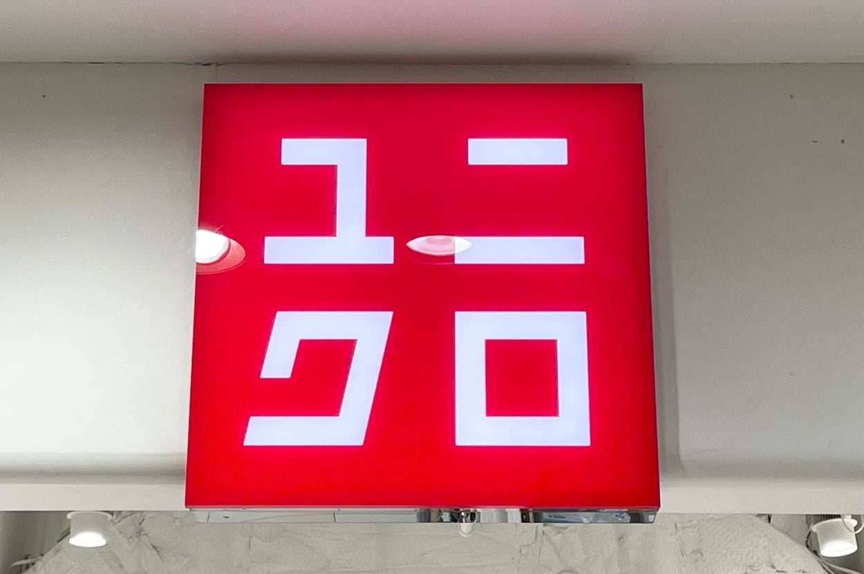 Sign with Japanese katakana letters spelling "Uniqlo" on a red background above a store entrance
