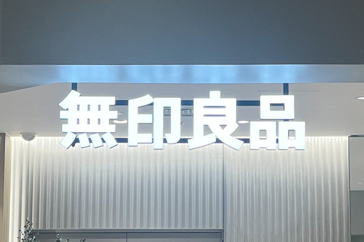 Storefront sign with Chinese characters for "Muji," a Japanese retail company known for minimalist designs and household products
