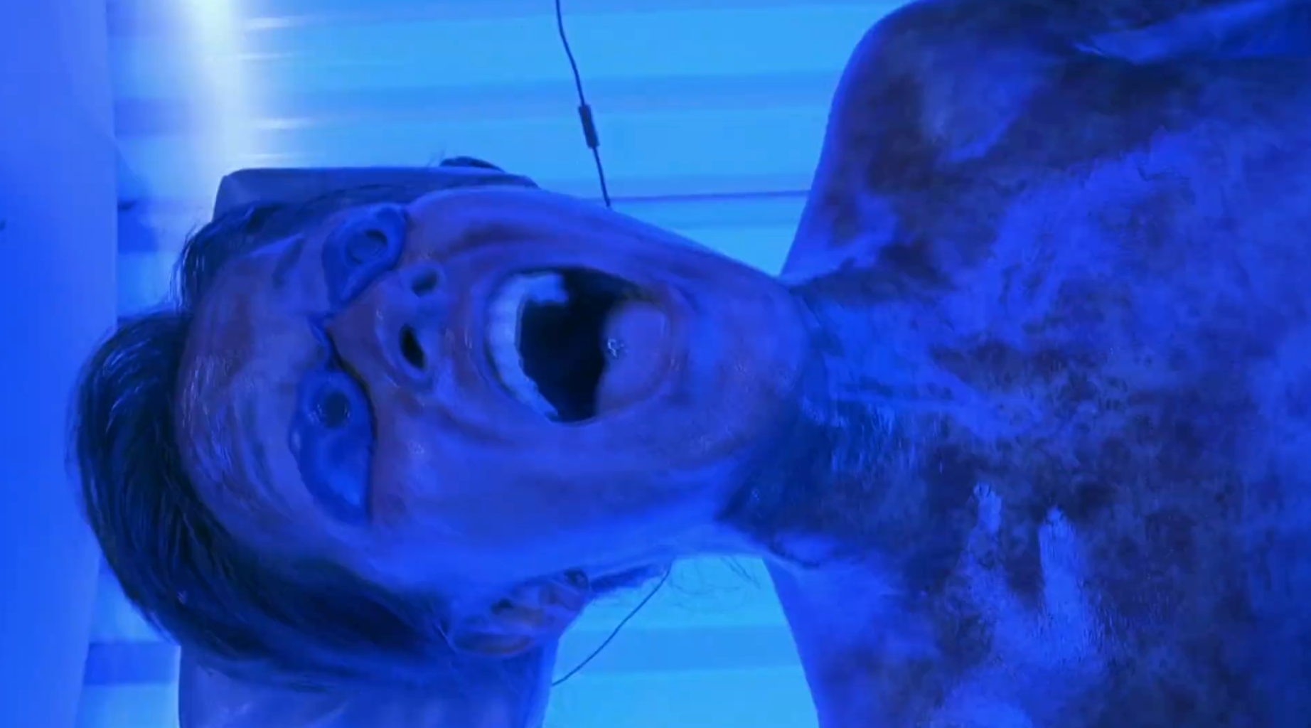 Person successful  a tanning furniture  screaming, with exaggerated bluish  lighting effect, perchance  from a country   successful  a movie  oregon  TV show