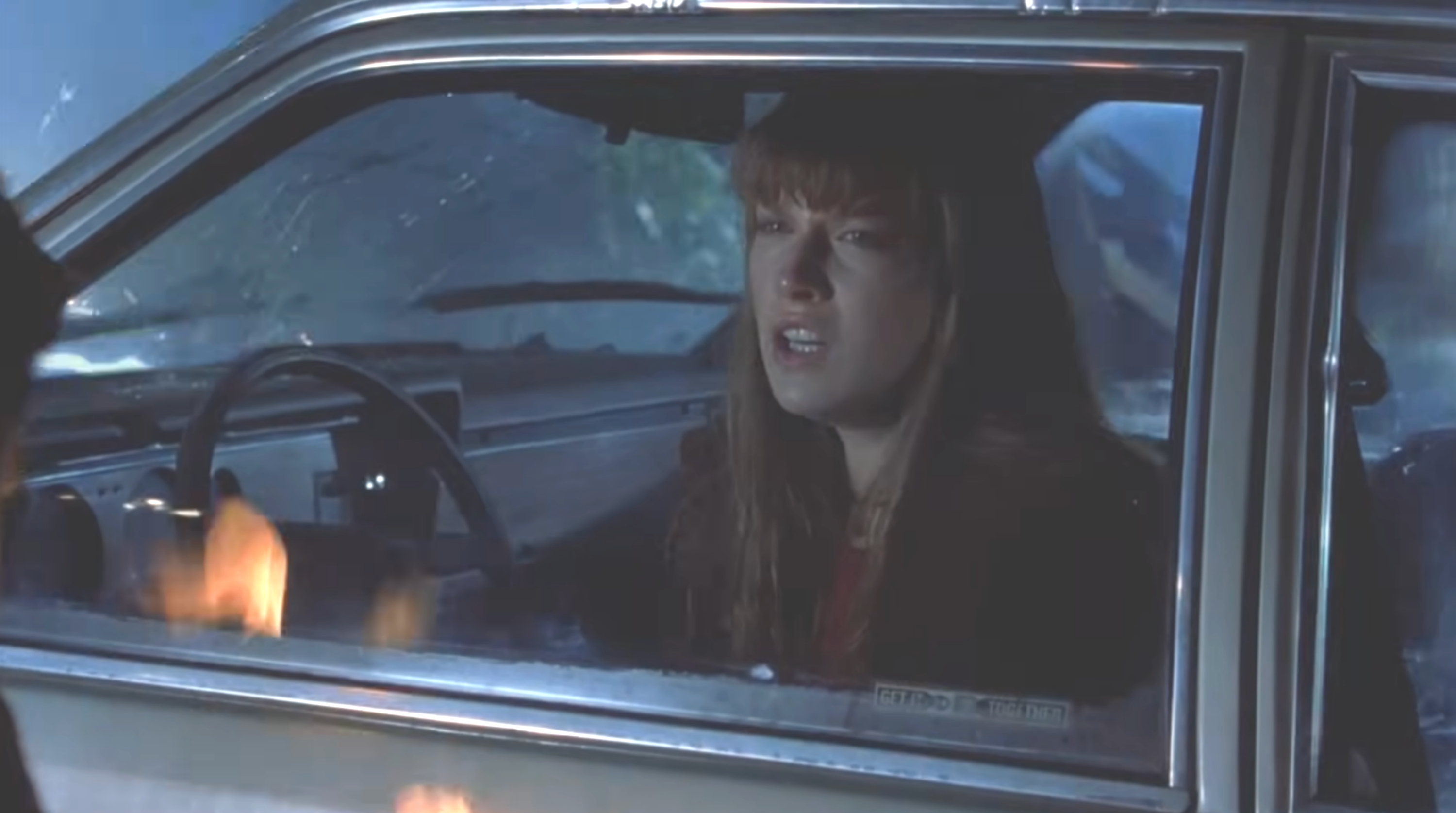 Person with a tense look  sits successful  a car   astatine  night, looking retired  the window. Scene suggests suspense oregon  play  from a TV oregon  movie