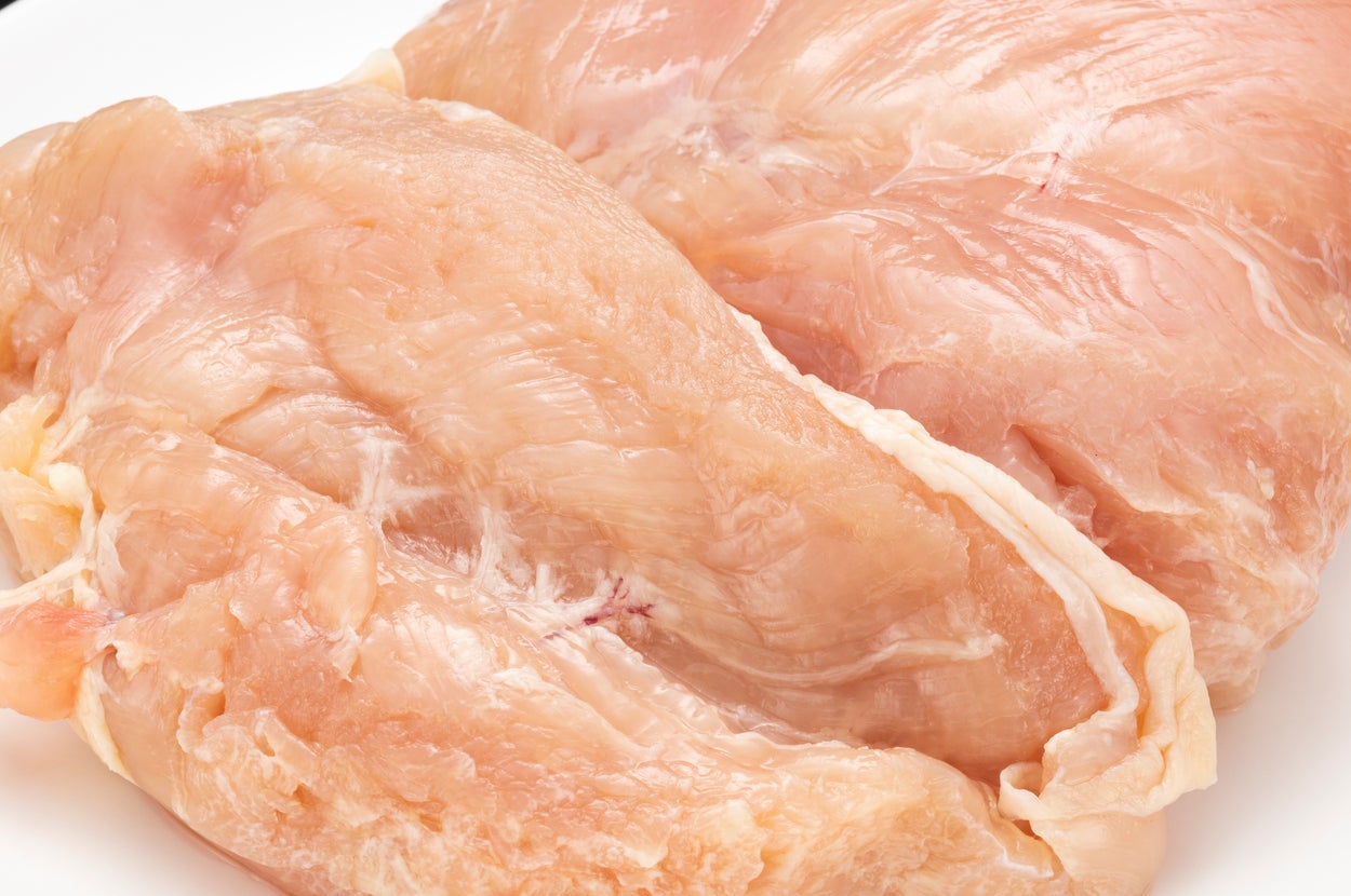 白い皿に生の鶏胸肉が2枚、整然と盛り付けられている様子。