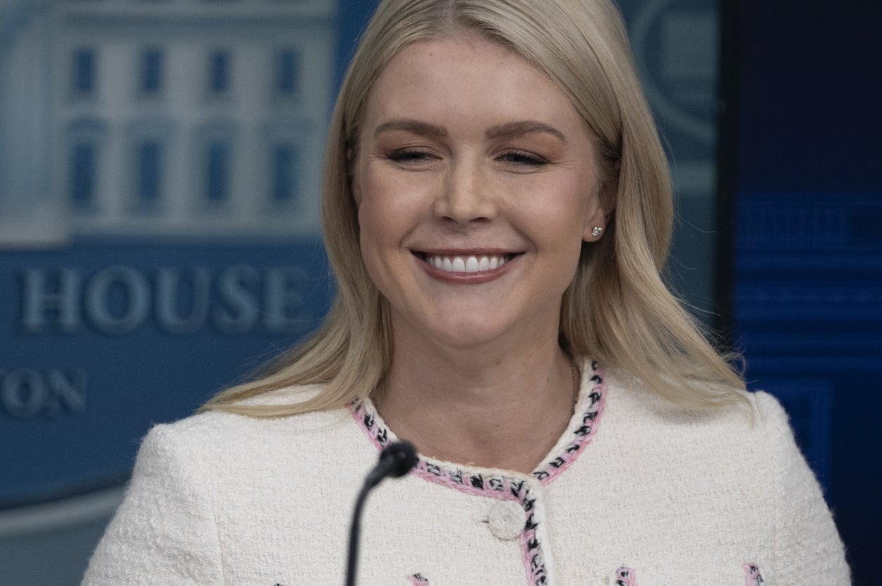 大統領執務室で、白いジャケットを着た女性が笑顔で立っている。