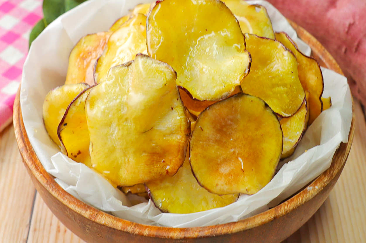 木製のボウルに入ったチップの山。付近にサツマイモがある。