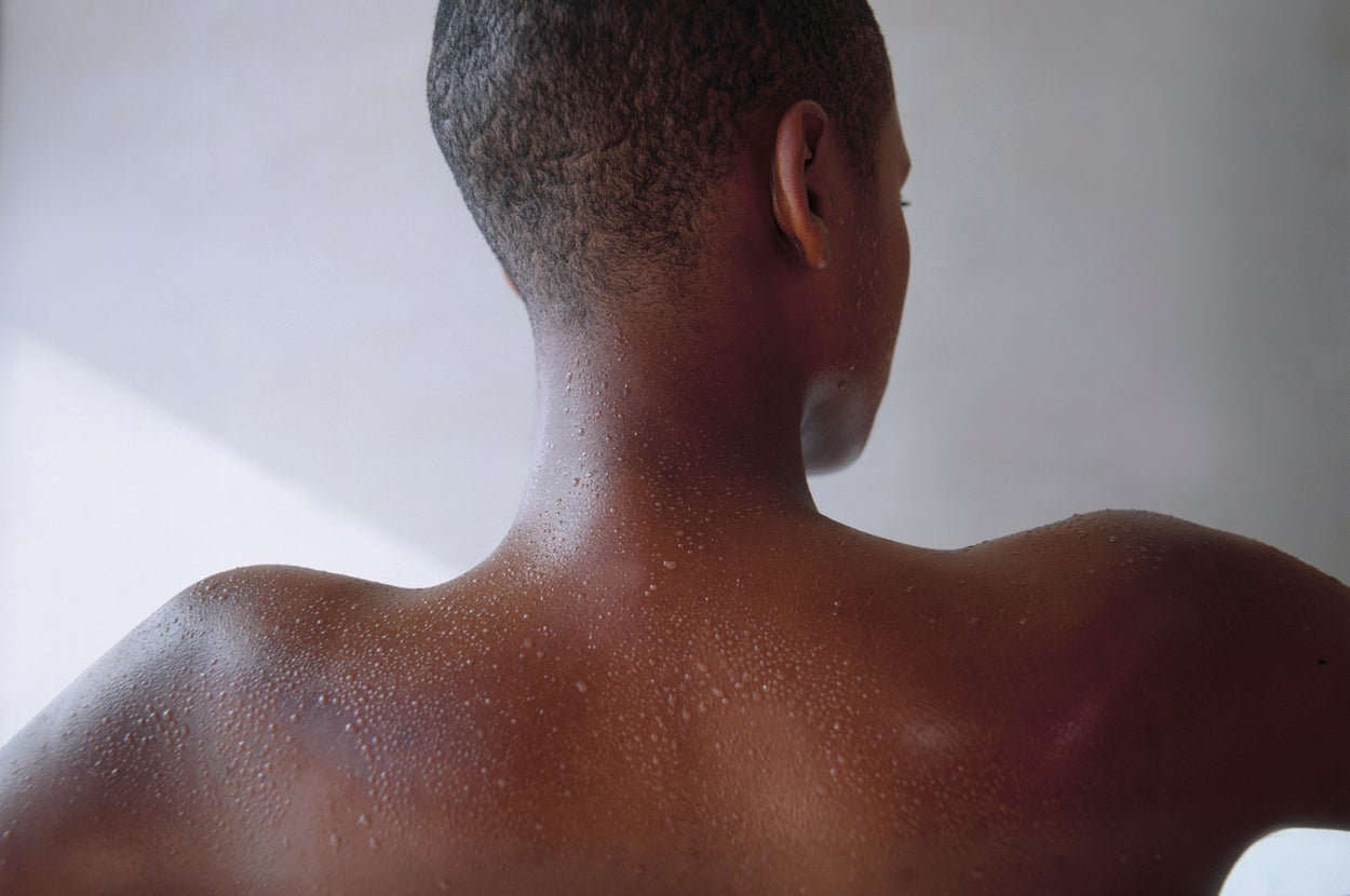 Person with wet skin relaxes in a bathtub, showcasing calmness and self-care