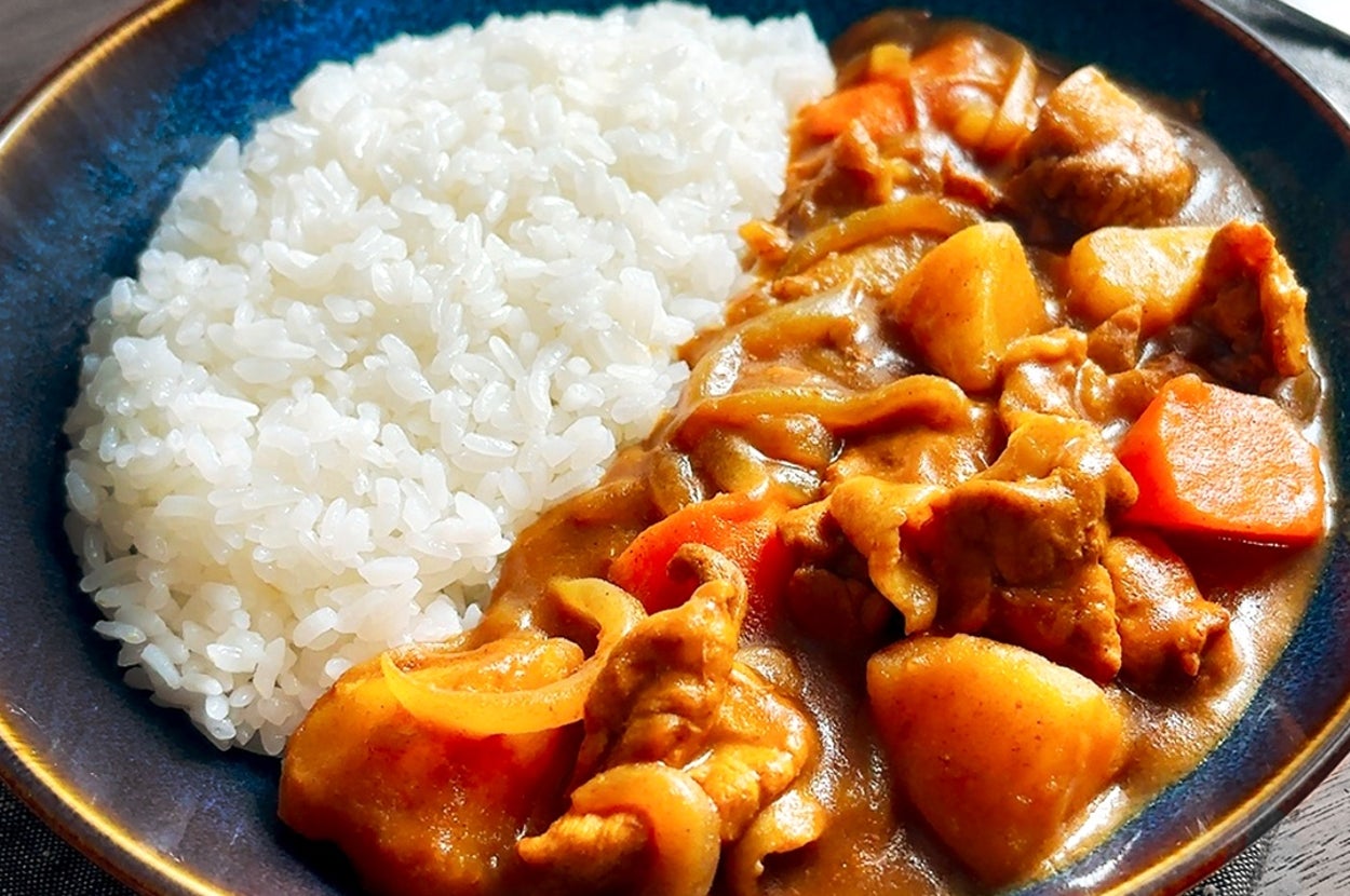 カレーライスのクローズアップ写真。白いご飯と具沢山のカレーが鮮やかに盛り付けられた料理が写っています。