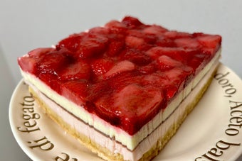 イチゴのスライスが載ったケーキの断面図。層状のクリームとスポンジが見える。