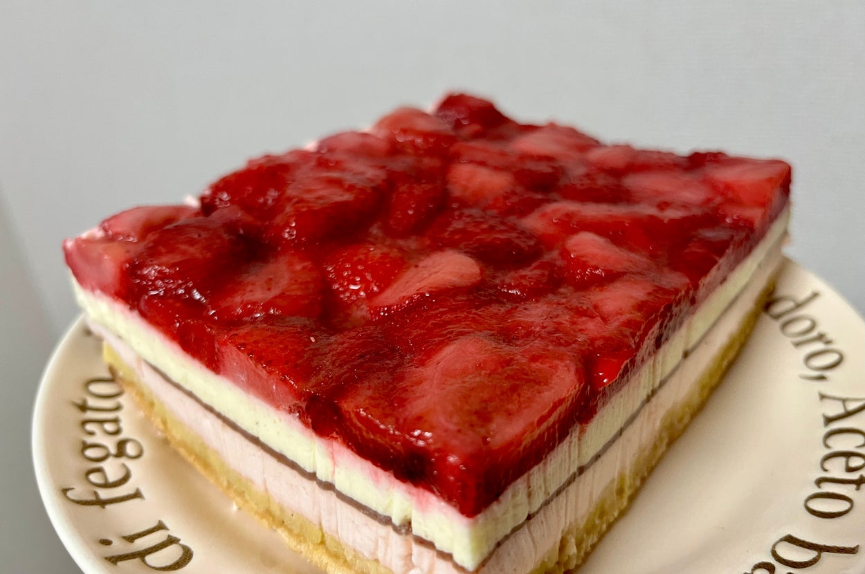 イチゴのスライスが載ったケーキの断面図。層状のクリームとスポンジが見える。