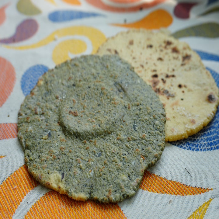 Two tortillas, one speckled and one plain, on a patterned surface