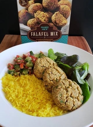 Plate with yellow rice, salad, and three falafels made from a mix. Falafel mix box is in the background