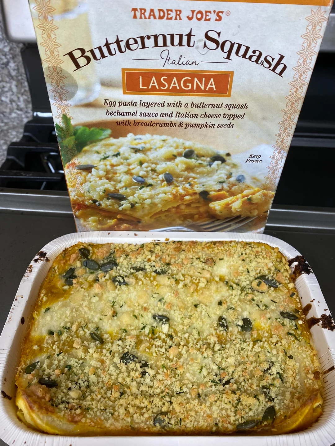 Trader Joe&#x27;s Butternut Squash Lasagna in packaging and baked, topped with breadcrumbs and pumpkin seeds