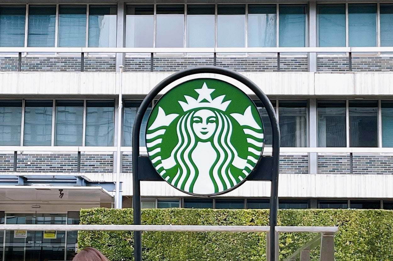 スターバックスのロゴがオフィスビルの前に掲げられている様子。