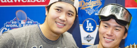 野球選手3人が、ワールドシリーズのトロフィーの前で「CHAMPIONS」と書かれたシャツを着てポーズを取っている。