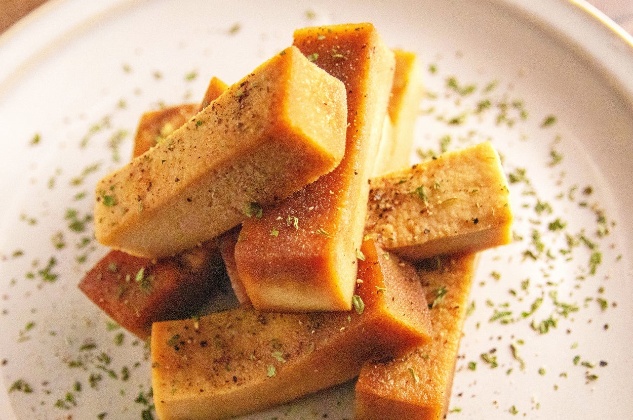 皿に盛られた厚い野菜の切れ端。ハーブとスパイスが振りかけられている。