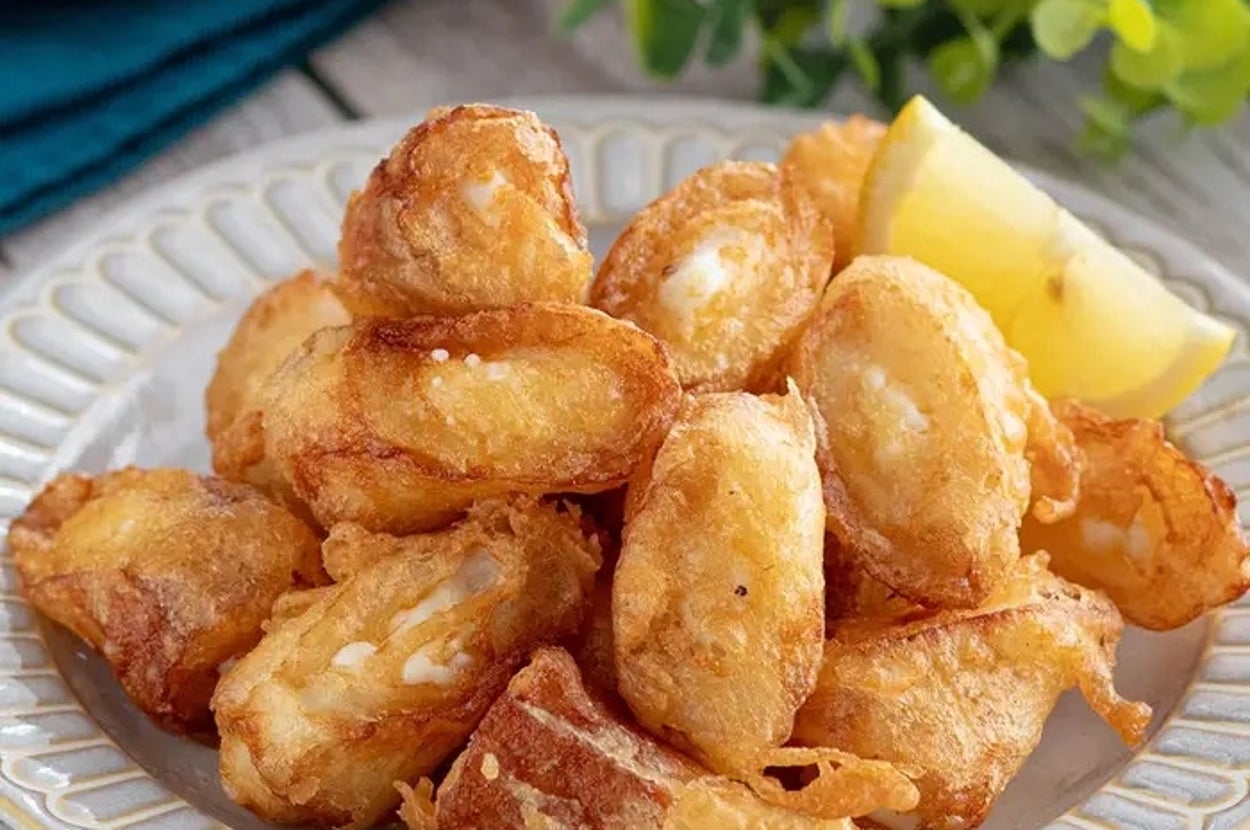 揚げたチーズの前菜がレモンのスライスと共に皿に盛られている。