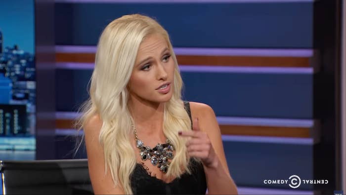 Person with long hair discussing a topic on a talk show, wearing a detailed necklace and a sleeveless top