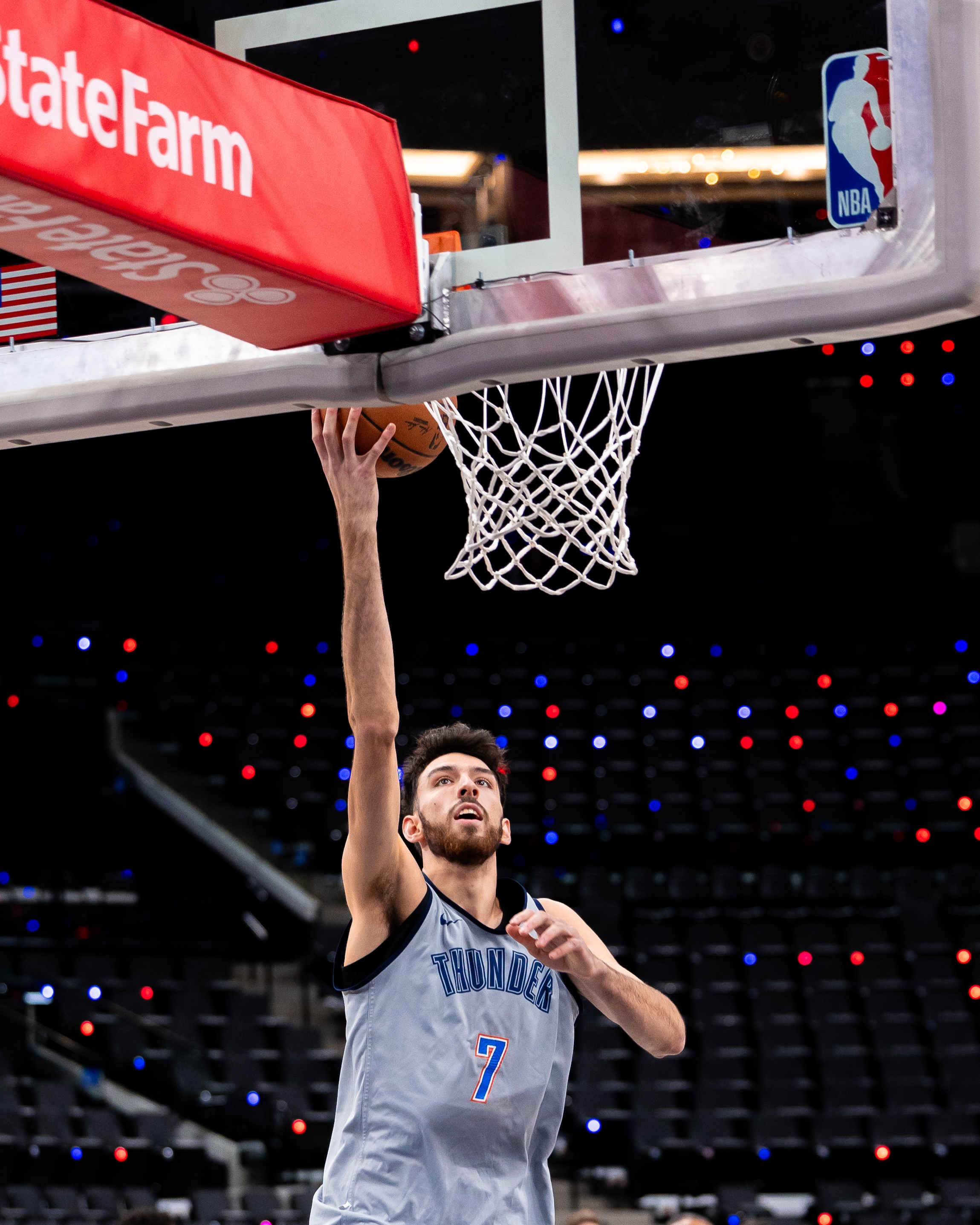 Basketball player wearing a Thunder jersey, number 7, goes for a layup during a game