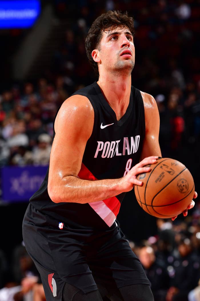 Basketball player in Portland jersey focused, preparing to take a free throw during a game
