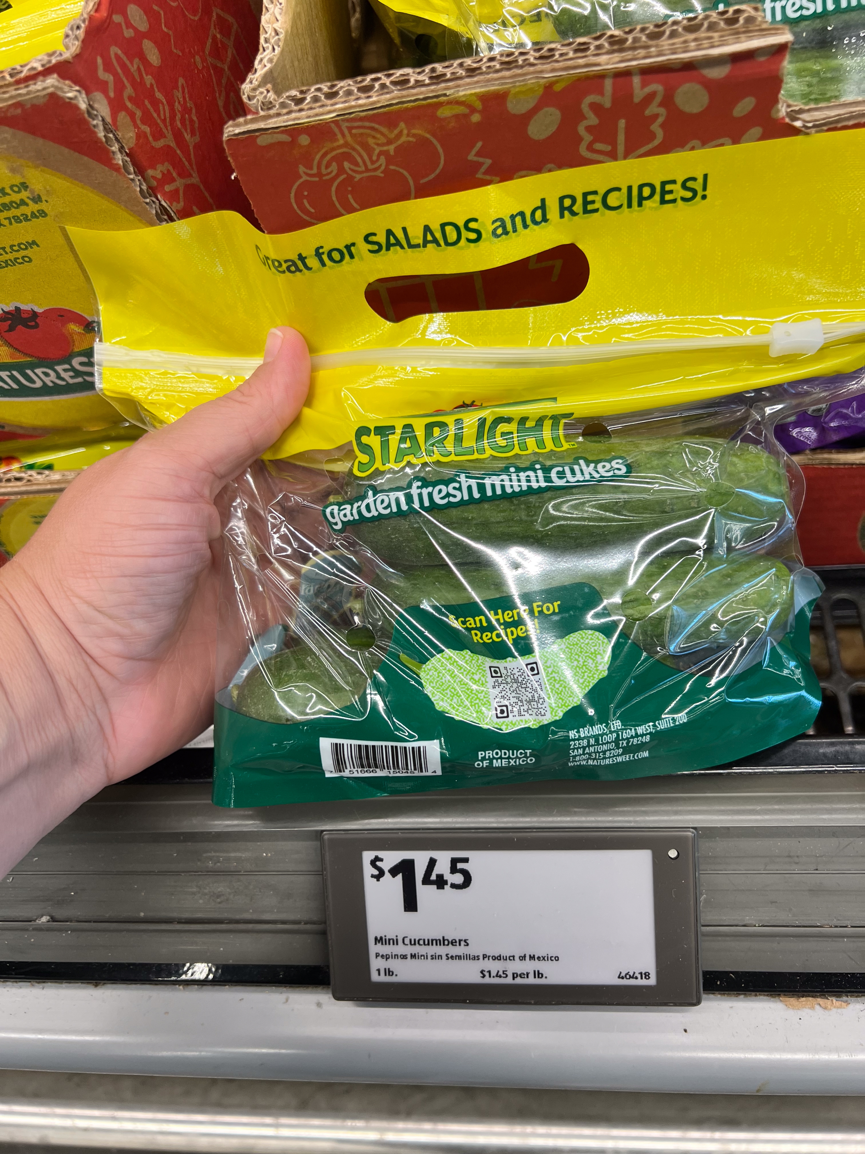Packaged mini cucumbers labeled &quot;Starlight Garden Fresh Mini Cukes,&quot; priced at $1.45. Displayed on a grocery store shelf