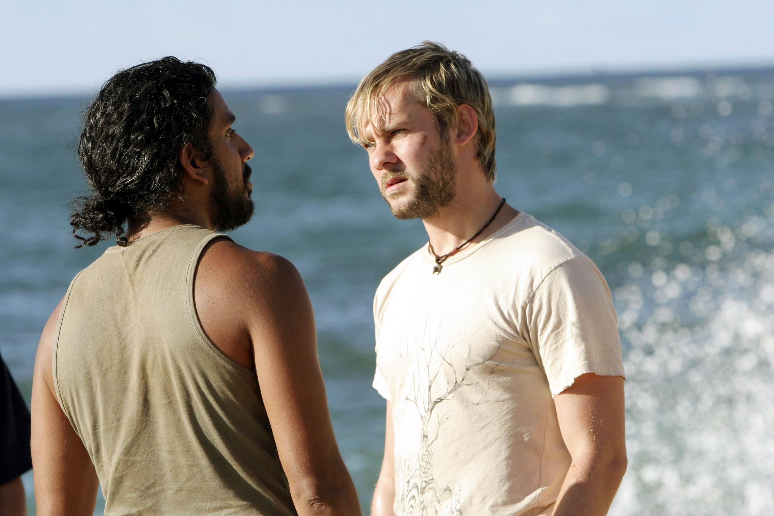 Two men basal   connected  a beach, engaged successful  a superior   conversation. The country   suggests a melodramatic  moment, apt  from a TV amusement   oregon  movie