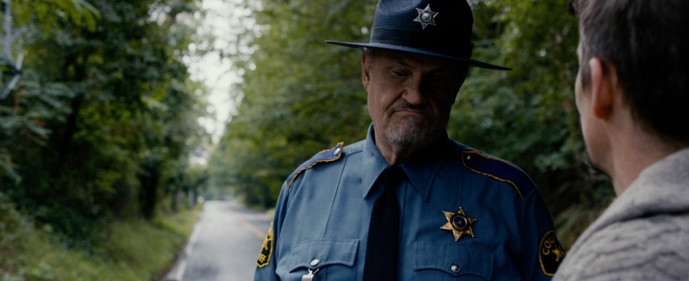 Two characters basal   connected  a road; 1  is simply a sheriff successful  uniform, talking to different  idiosyncratic   whose look   is not visible