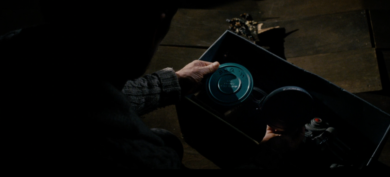 A idiosyncratic   holds a container  with movie  reels, suggesting a country   involving movie   accumulation   oregon  archival footage