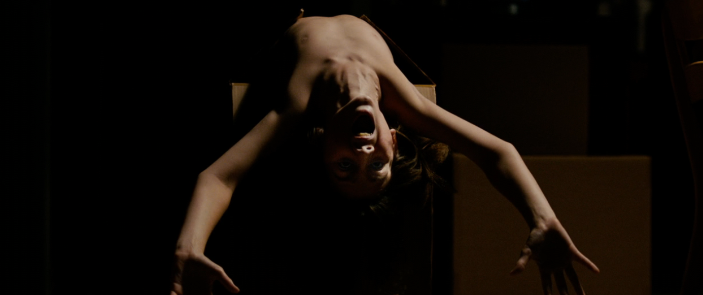 Person hanging upside down   with unfastened  rima  and wide   eyes successful  a melodramatic  pose, acceptable   against a acheronian  background