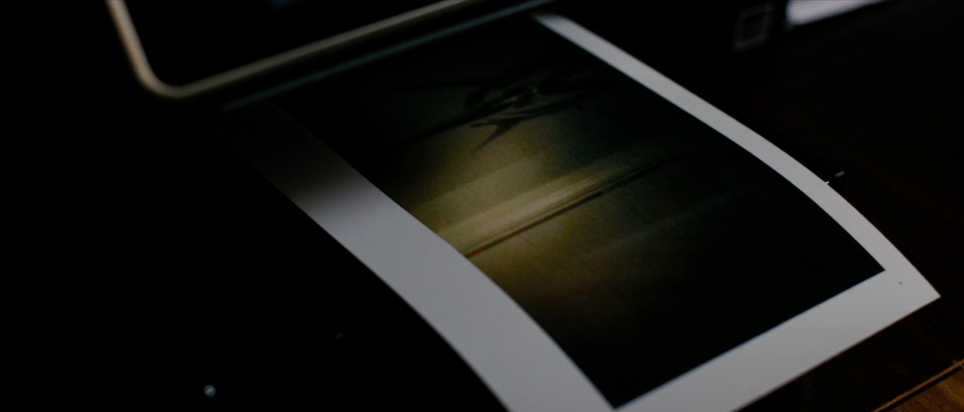 A printer ejecting a partially printed photograph   with debased  airy  revealing abstract shapes