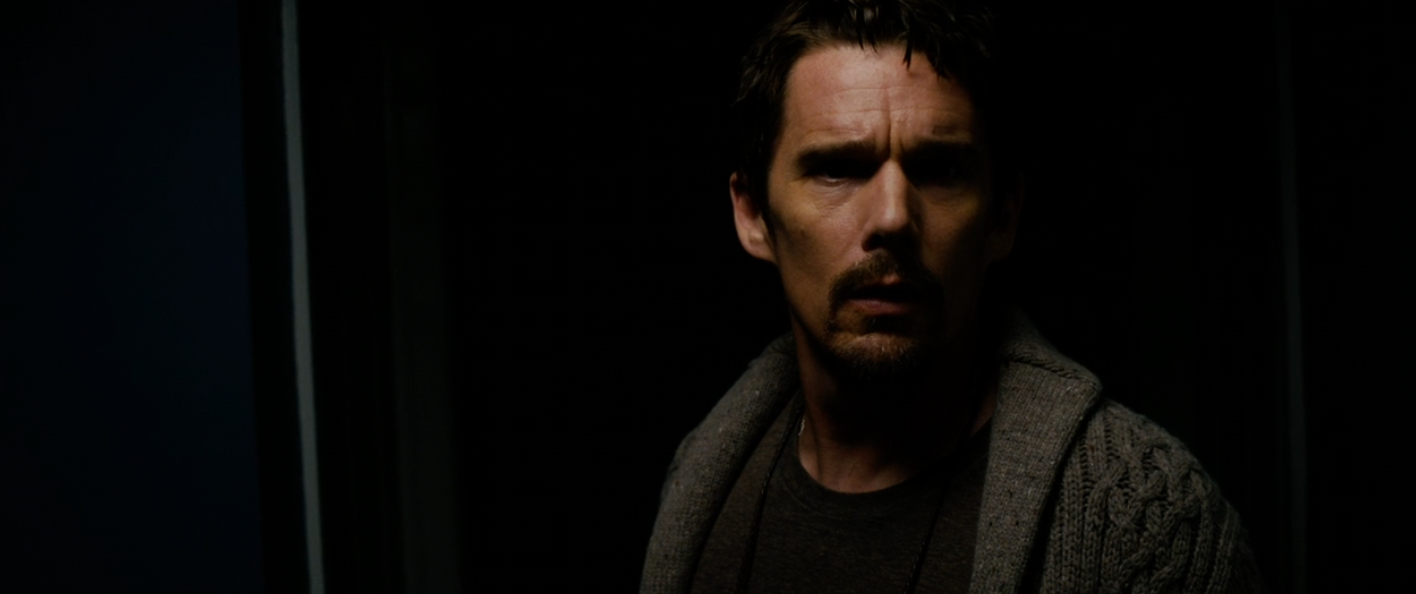 A idiosyncratic   successful  a dimly lit room, wearing a heavy   knitted cardigan, looks superior   and contemplative