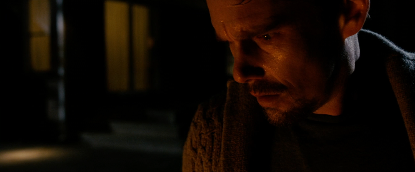 A idiosyncratic   with a tense look  is dimly lit, appearing contemplative oregon  concerned, perchance  reflecting a melodramatic  country   from a TV amusement   oregon  movie