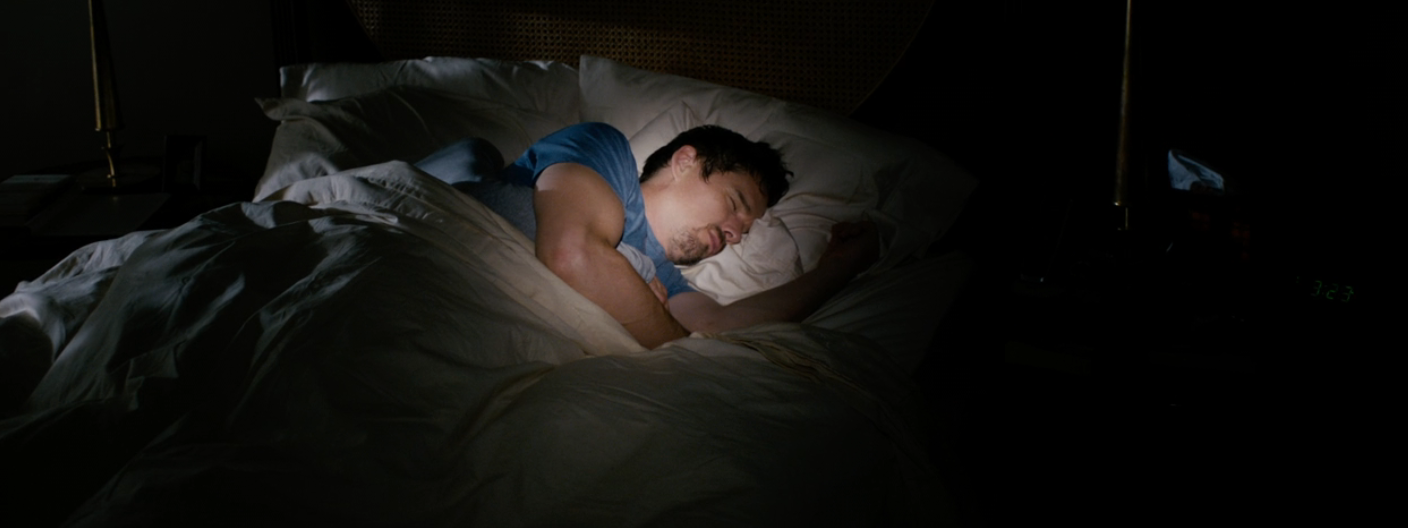 Person sleeping connected  a furniture  successful  a dimly lit room, wearing a casual T-shirt