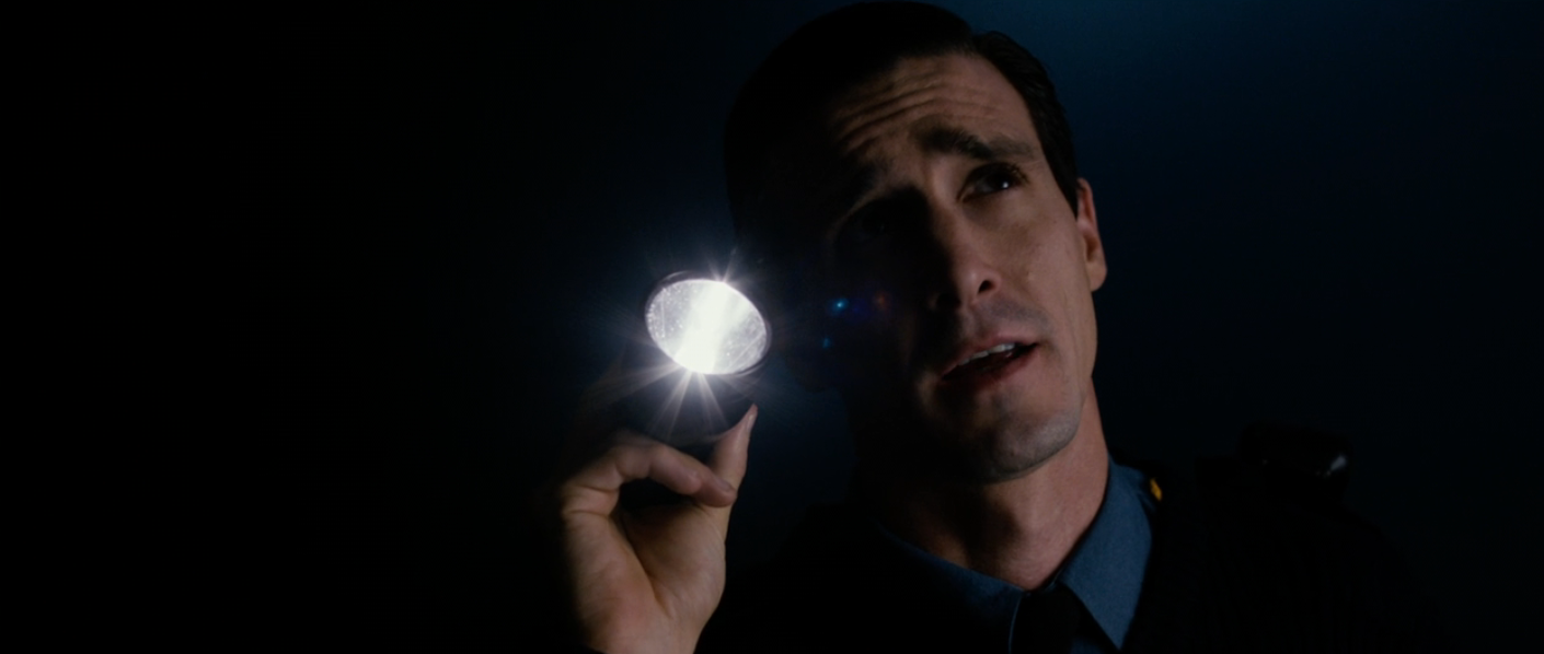 A idiosyncratic   successful  a dim mounting  holds a flashlight up   to their face, casting airy  upward, suggesting suspense oregon  mystery