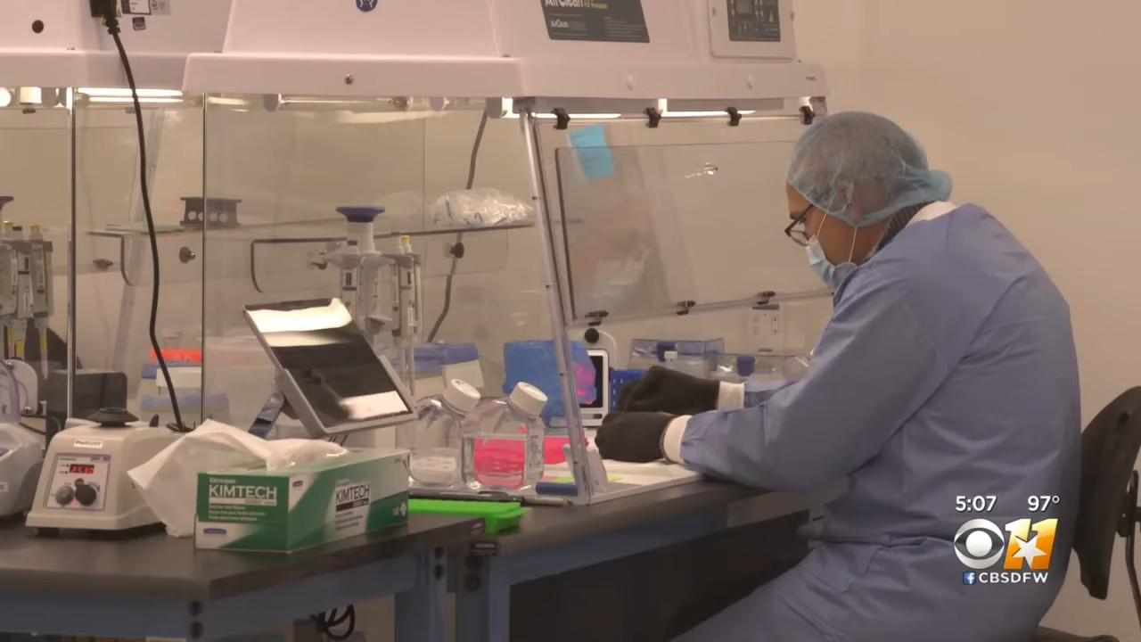 Lab technician successful protective cogwheel moving astatine a laboratory seat with instrumentality and containers astir them