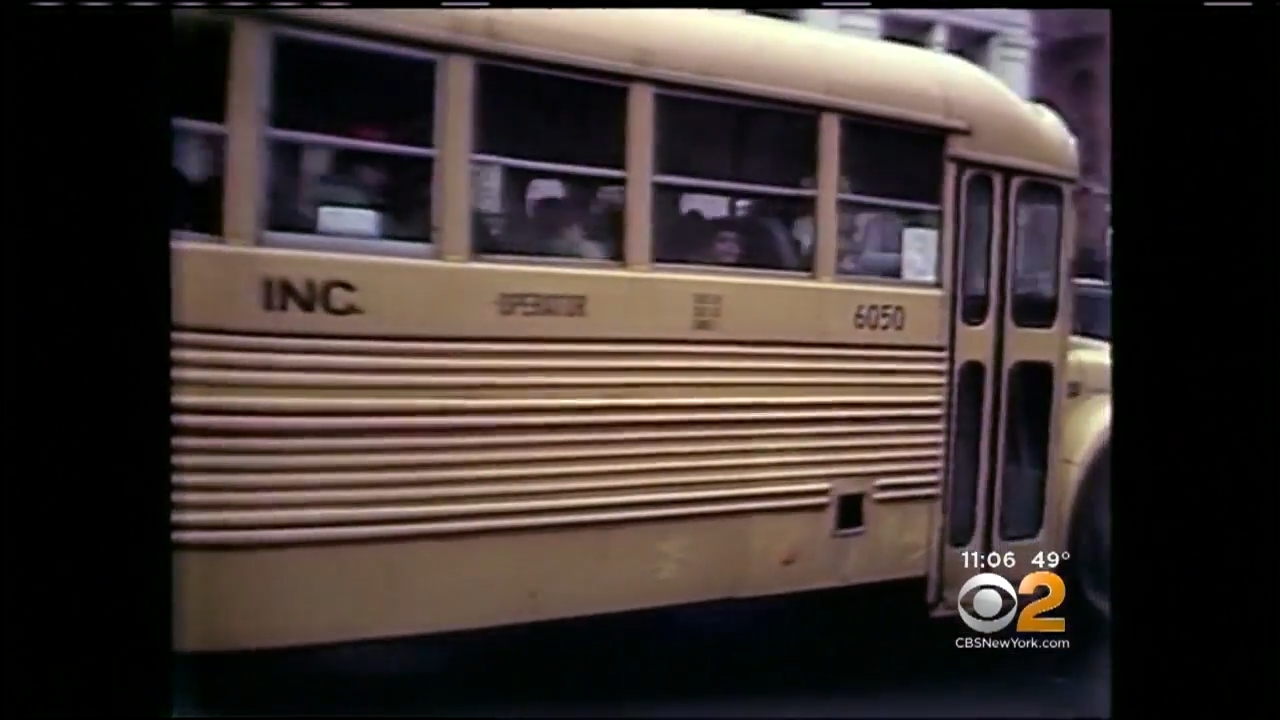 A vintage schoolhouse autobus with windows partially open, filled with students, captured successful question connected a metropolis street. CBS2 New York timestamp visible