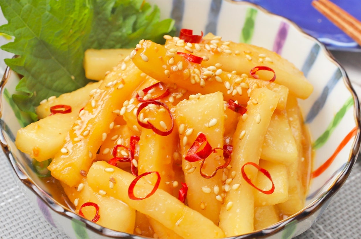 ゴマと唐辛子がトッピングされたユッケジャンのような風味の大根の和え物が器に盛られている。